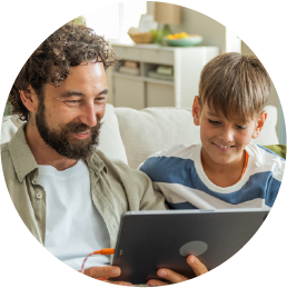 Man and boy sitting together looking at a screen